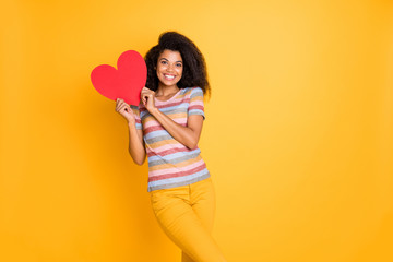 Portrait of nice attractive cheerful cheery wavy-haired girl in striped t-shirt holding in hands heart human health care clinic center isolated on bright vivid shine vibrant yellow color background