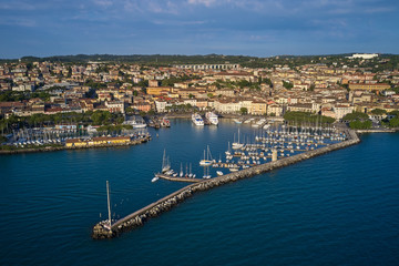 Fototapeta premium Aerial view of the city center of Desenzano del Garda, Italy. The main lighthouse of the city, boat parking in the city center