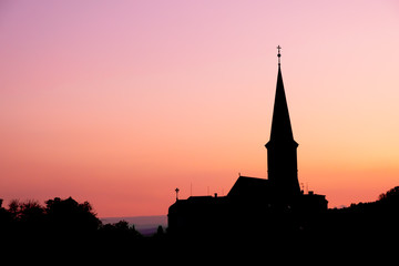Obraz premium Silhouette view of parish Orthodox church in the evening at Gumpoldskirchen, a famous place for its wine and Heurigers as a great hillside vineyards.