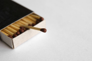 Wooden safety matchsticks stacked in cardboard matchbox.