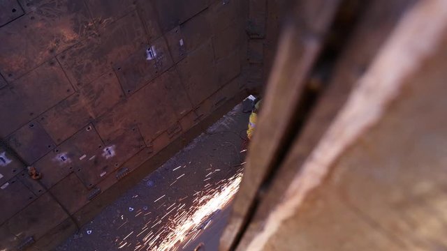 Footage of rope access industrial technician miner fitters, boilermaker wearing fully safety harness, helmet head welding mask eyes protection abseiling working maintenance  using oxy cutting lifting 