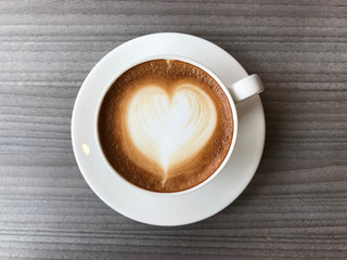 Top view of a cup of hot coffee on wooden background