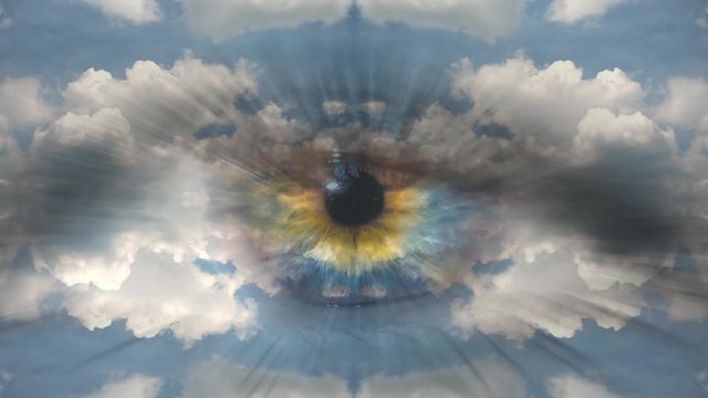 Creative 4k time laps video of moving clouds with reflection and mirror effect as in a kaleidoscope and multi-colored human eye macro close-up moving to the camera. The idea of God, the higher mind.