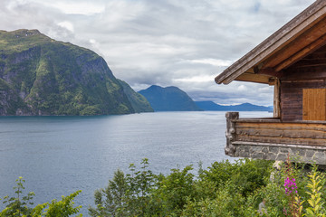 Fototapeta na wymiar small house in the mountains of the Norwegian fjord with turquoise water