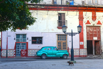 Green retro car parking on the street in Havana