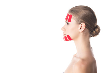 Side view of kinesiology tapes on chin and forehead of beautiful girl isolated on white