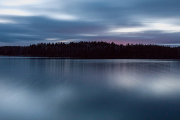 The sun setting over the lake with some interesting clouds in the sky. Sweden