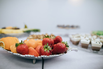  Delicious fresh fruit on a silver tray, strawberries, grapes, pineapple, orange. Fruit desserts
