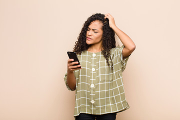 young black woman feeling puzzled and confused, scratching head and looking to the side with a...