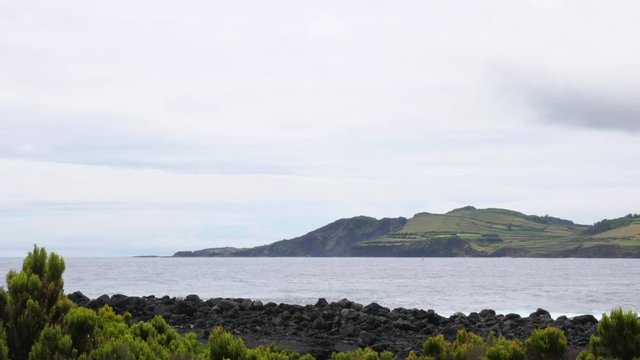 A shot of a landscape in Azores. Ocean and green vegetation
