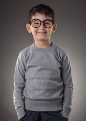 cute smiling boy in glasses on gray background. Studio portret © Dmytro Titov