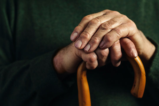 Hands of a senior man clasping a cane