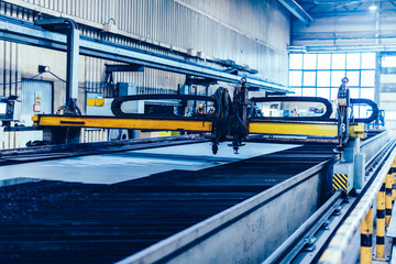 Flame cutting process with steel profiling machine in a factory