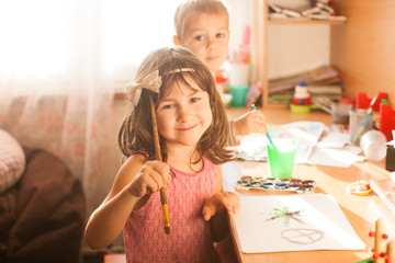 Cute kids painting with paintbrush and colorful paints