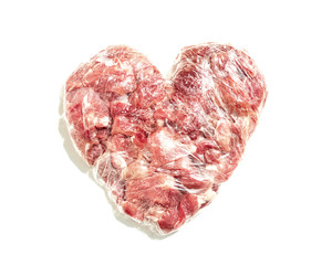 Fresh meat in shape of heart on white background with food film, cutlet for cutlets
