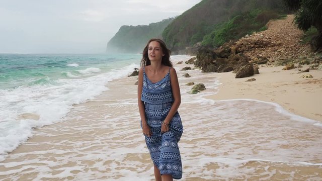 Woman walking alone on empty beach