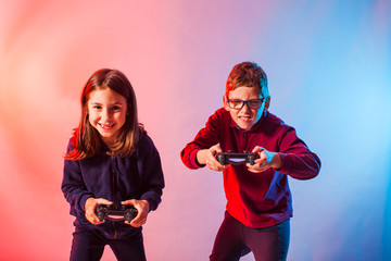 Excited kids with joysticks playing an interesting virtual game