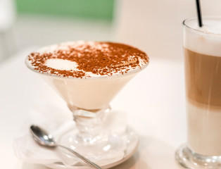 Tiramisu in a glass sprinkled with cocoa, trace from a spoon
