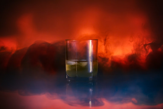 Cocktail in a glass rox glass with ice smoke burns on Lush Lava background. Close up
