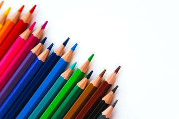 bright multi-colored flat lay pencils for drawing on a white background, place for text 