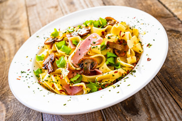 Tagliatelle with ham and chmpignon wooden table