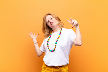 middle age woman shrugging with a dumb, crazy, confused, puzzled expression, feeling annoyed and...