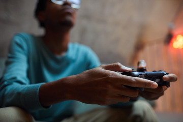 Close up of contemporary African-American man holding gamepad controller while playing videogames © Seventyfour