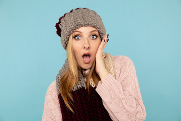 Amazed female in the winter hat and scarf and sweater