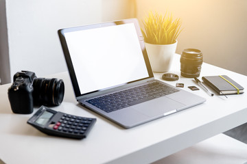 Vista del espacio de trabajo con cámara, ordenador portátil y calculadora. Lugar de trabajo del fotógrafo y diseñador freelance