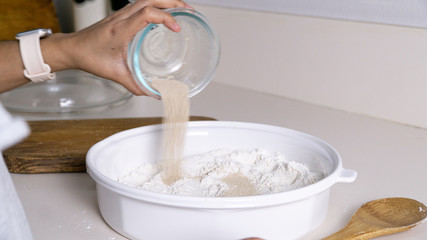 hands mixing dough on wooden table