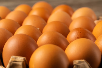 Chicken eggs in box on wooden table.