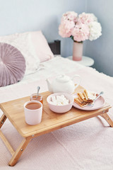Breakfast in bed in hotel room. Accommodation. Breakfast in bed with tea cup with pancakes on tray...