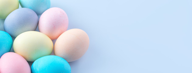 Colorful Easter eggs dyed by colored water isolated on a pale blue background, design concept of Easter holiday activity, close up, copy space.
