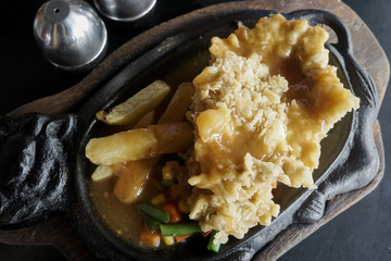 steak tenderloin on a hot plate with potatoes, corn and carrots