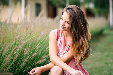 Portrait of a beautiful young girl in green summer grass. Soft selective focus.