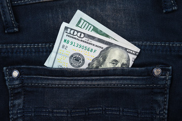 One hundred dollar banknote money in pocket jeans pants background texture. 100 dollar bill close up