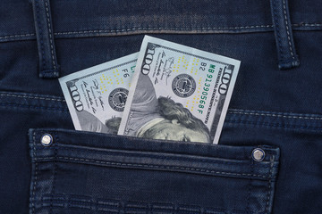 One hundred dollar banknote money in pocket jeans pants background texture. 100 dollar bill close up