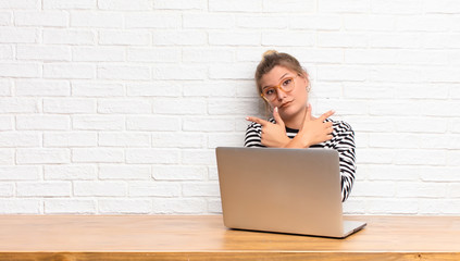 young pretty latin woman looking puzzled and confused, insecure and pointing in opposite directions with doubts sitting with her laptop