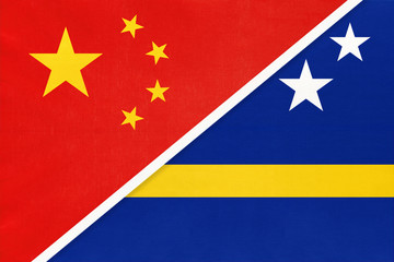 China or PRC vs Curacao national flag from textile. Relationship between asian and american countries.