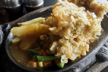 steak tenderloin on a hot plate with potatoes, corn and carrots
