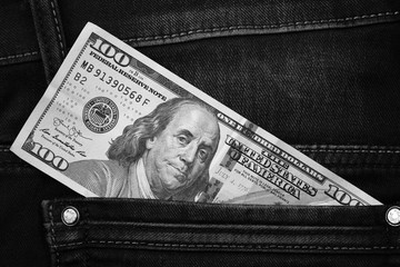One hundred dollar banknote money in pocket jeans pants background texture. 100 dollar bill close up