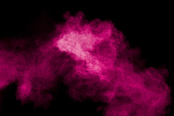 Obraz na płótnie Canvas Pink powder explosion on black background.Pink dust splash cloud on dark background.