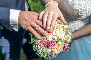 hands groom and bride with wedding rings and wedding bouquet flowers celebration love symbol