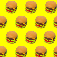 Plastic toy burgers on a yellow background, seamless pattern.