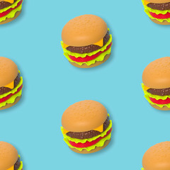 Plastic toy burgers on a blue background, seamless pattern.