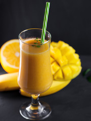 High glass of smoothie cocktail with mango orange and banana. Exotic healthy Breakfast