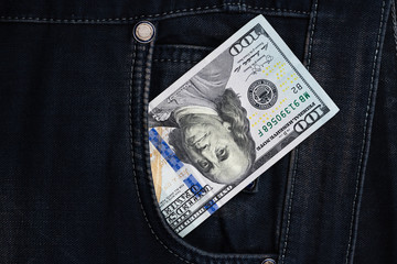 One hundred dollar banknote money in pocket jeans pants background texture. 100 dollar bill close up