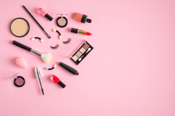 Set of makeup cosmetics and beauty products on pastel pink background. Flat lay, top view