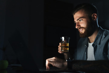 Confident young man working on laptop computer
