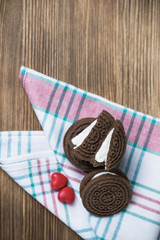 chocolate cookie sandwich on a colored napkin on a wooden background. wooden and red hearts. happy Valentine's day. beautiful picture with biscuits. texture.